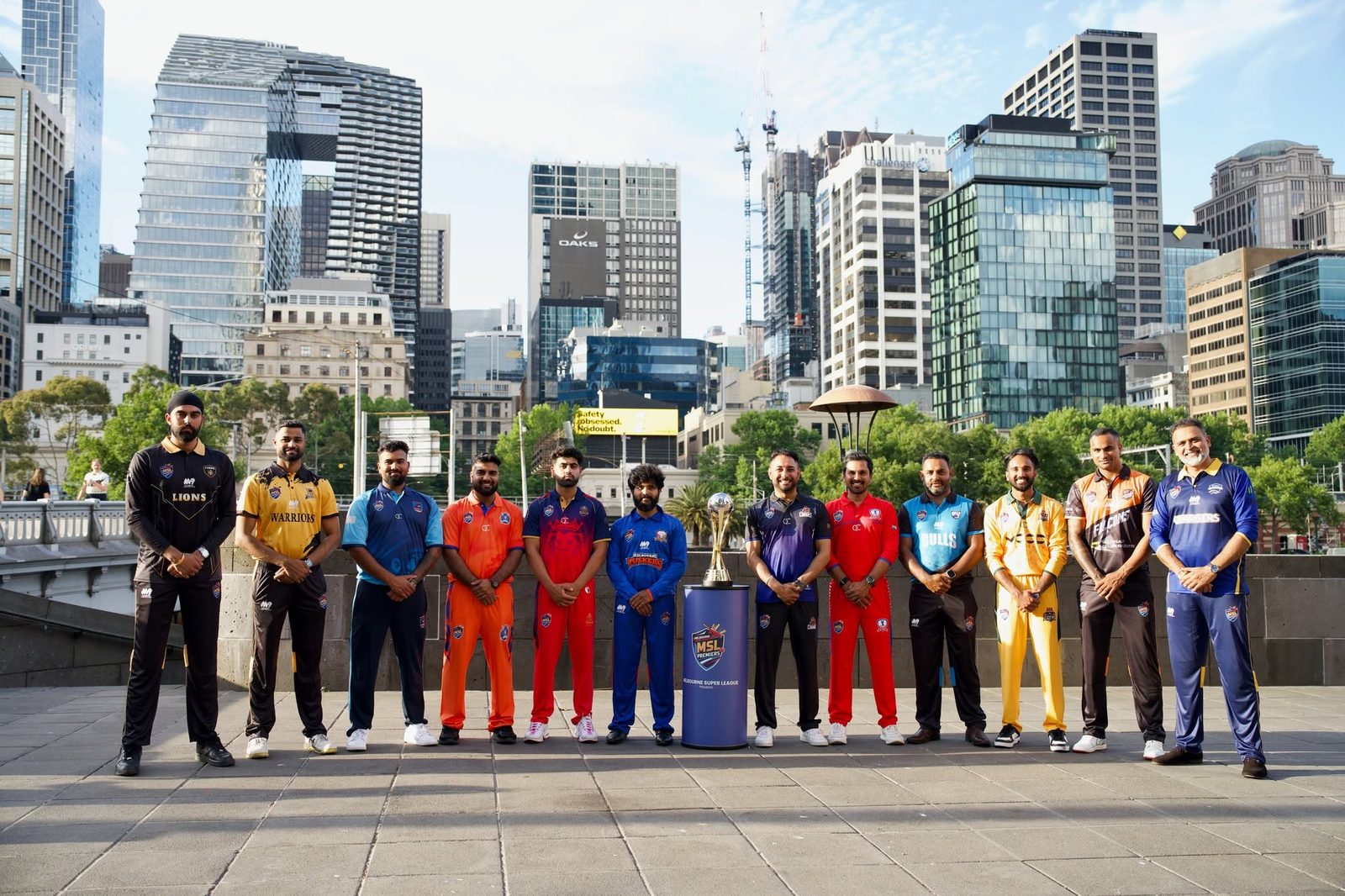 MSL Premiers club captains with the trophy in front of the Melbourne skyline